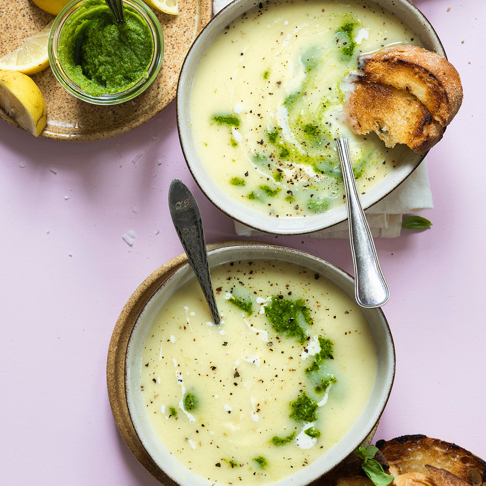 Cremet blomkålssuppe med kokosmælk toppet med grøn persillepesto i en dyb skål