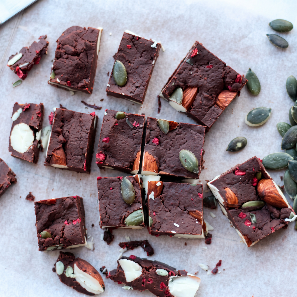 Cacaofudge med ceremonial cacao, nødder og frysetørret hindbær skåret i stykker