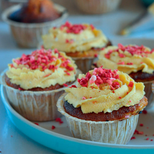 Gulerodscupcakes med kokosglasur og citronskal pyntet festligt