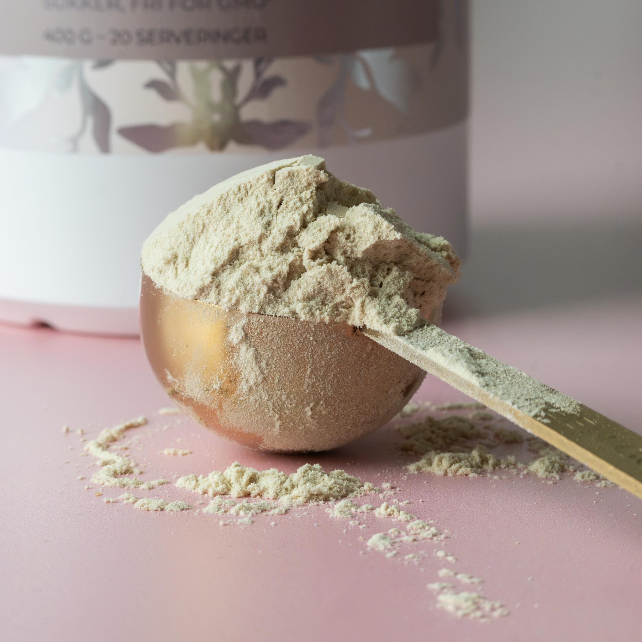 Messingfarvet scoop (måleske) med vaniljeprotein
